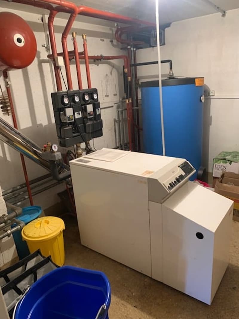 white heating system, blue water tank, yellow bucket, blue bucket, red pipes, metal ladder