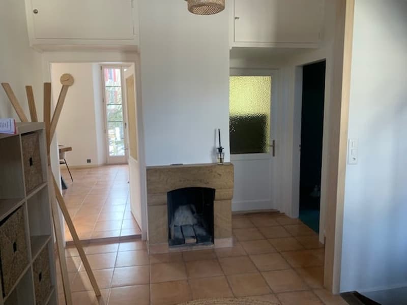 empty room, fireplace, tiled floor, wooden frame, white walls, two doors