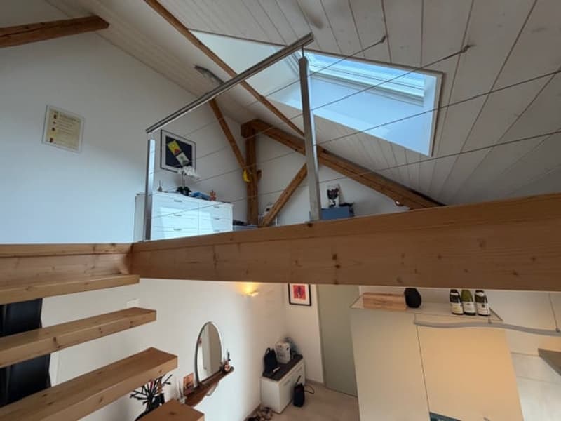 High ceiling, wooden beams, skylight, raised ground floor, wooden stairs, mirror, desk, storage boxes, bottle