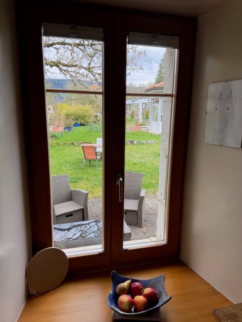 sliding glass door, wooden floor, bowl of fruit, view of garden