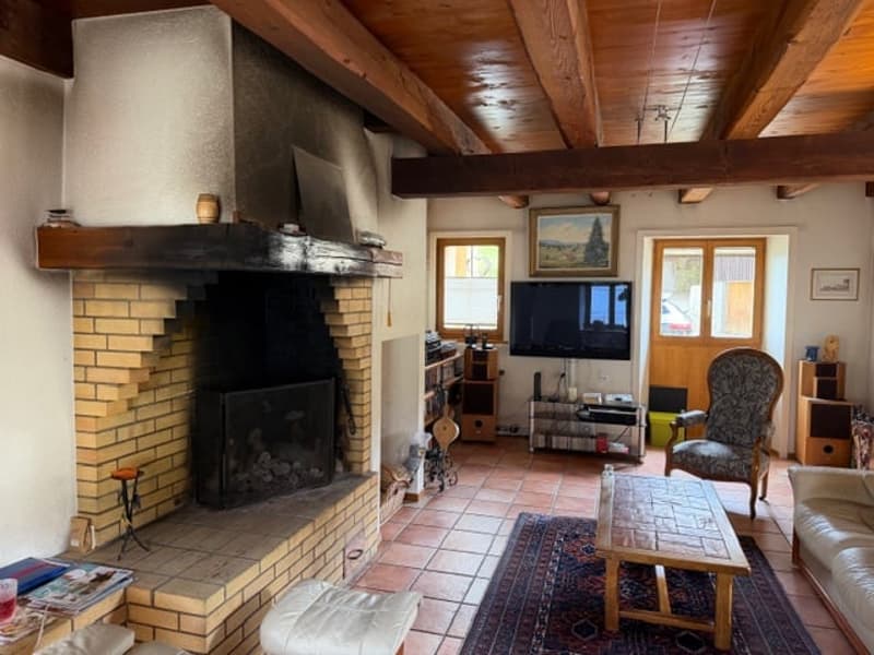 Fireplace, tiled floor, couch, armchair, coffee table, rug, television, entertainment center, picture frames