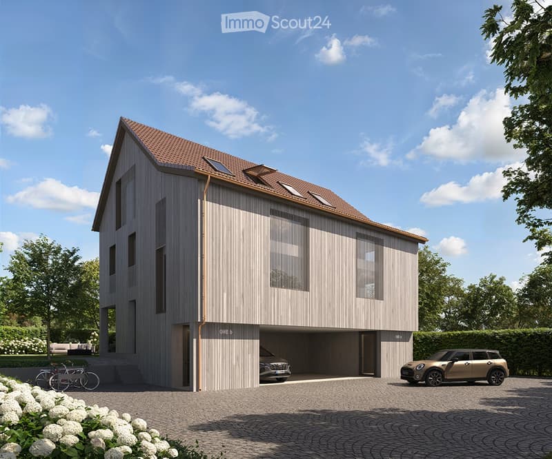 2-story modern house with a gray wooden exterior, a tiled roof, and large windows. The house has a garage and a parking space in the front. The surrounding area features landscaping with trees and flowers.