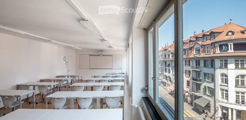 modern classroom with white desk and chairs, whiteboard, modern lighting, large window with view of city