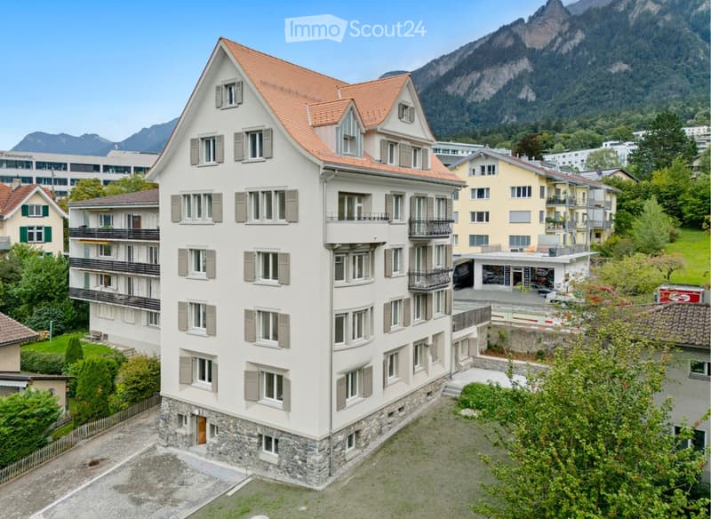 modern 6 story apartment building, beige color, brown roof, windows with gray shutters, multiple balconies