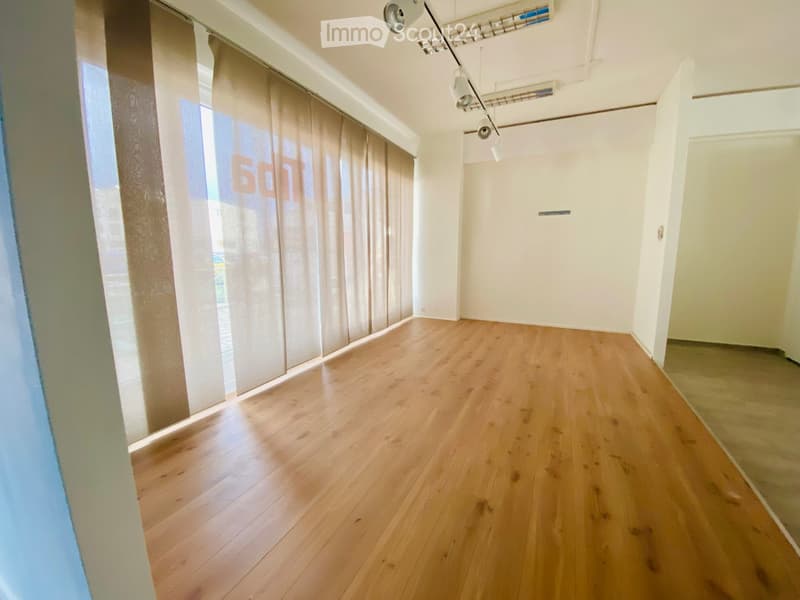 empty room, wooden floors, large windows with curtains, ceiling lights