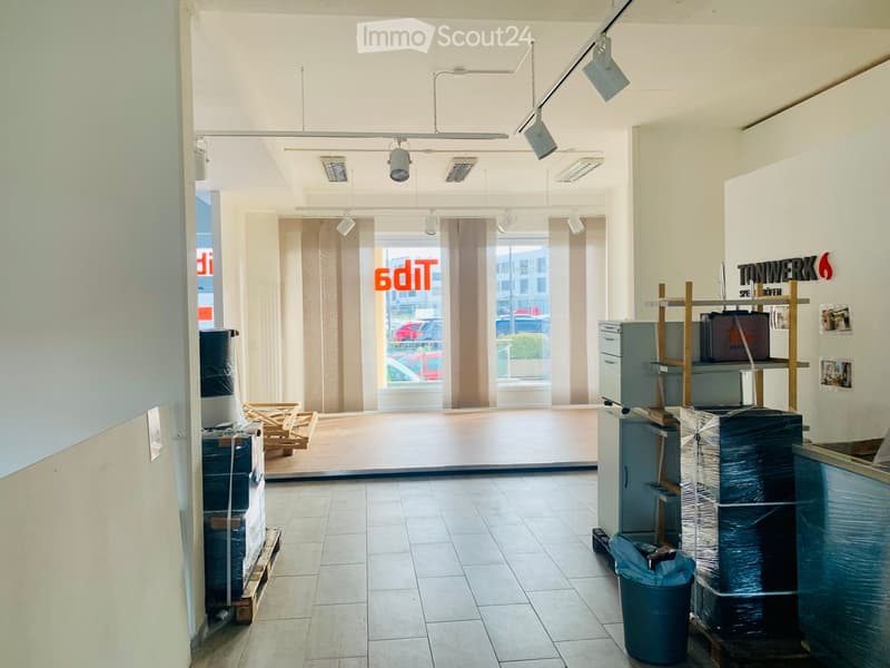 empty office, wooden floor, large window with curtains, light fixtures, storage boxes and barrels