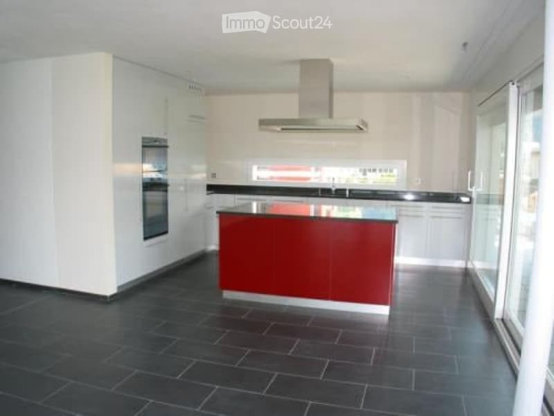 modern kitchen with white and red cabinets, central island, large windows