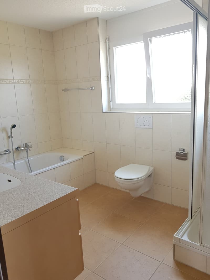 Bathroom with bathtub, shower stall, toilet, sink and tiled flooring.