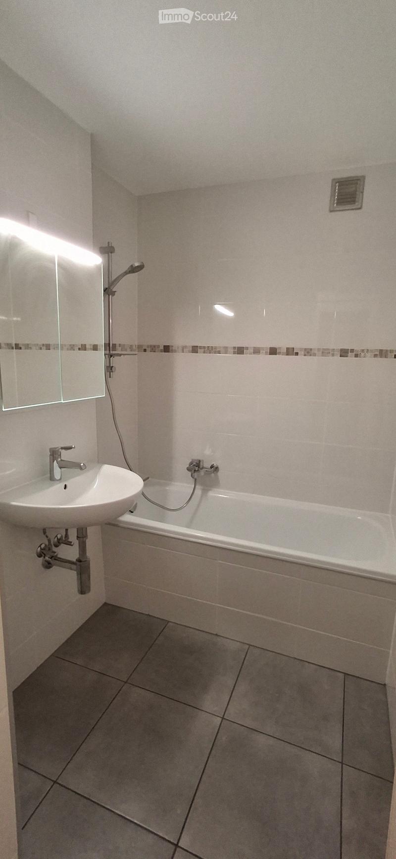 Tiled bathroom with bathtub, sink, shower, and mirror