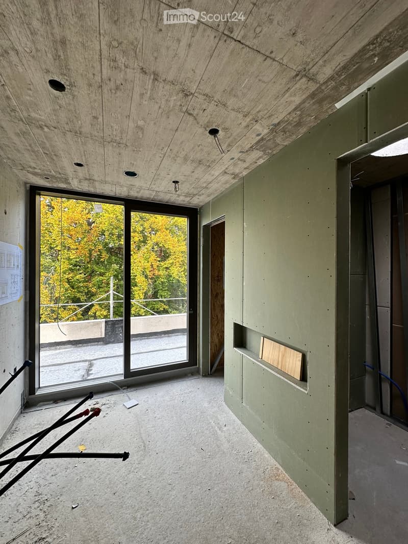large window, wooden pole, unfinished room, wire hanging, concrete floor