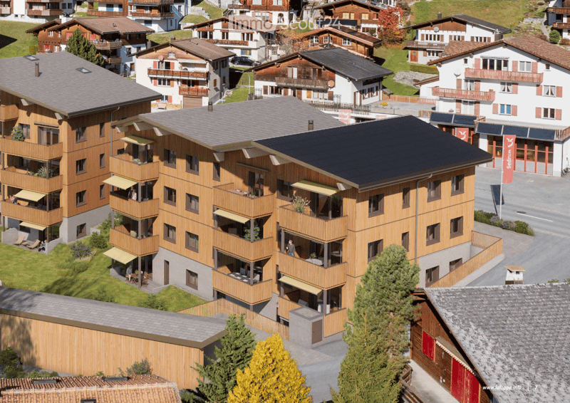 Apartment complex, 4 floors, wooden exterior, solar panels, balconies, green lawn