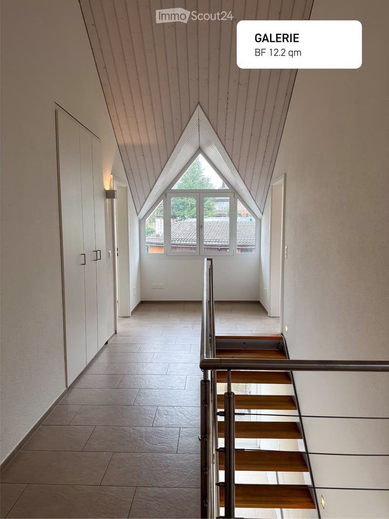 white ceiling, white walls, brown tile flooring, white doors, modern staircase with metal railing, attic room