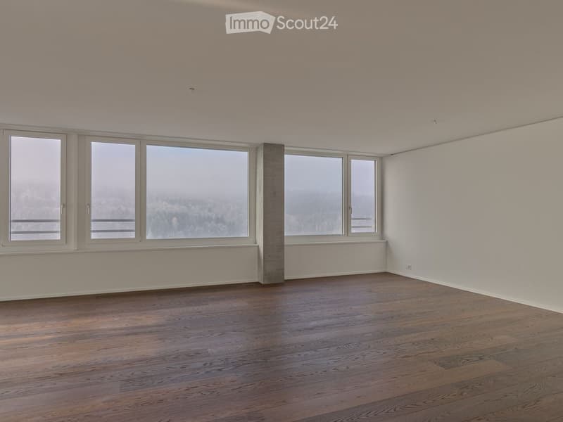 Empty room with large windows, balcony, and hardwood floors.
