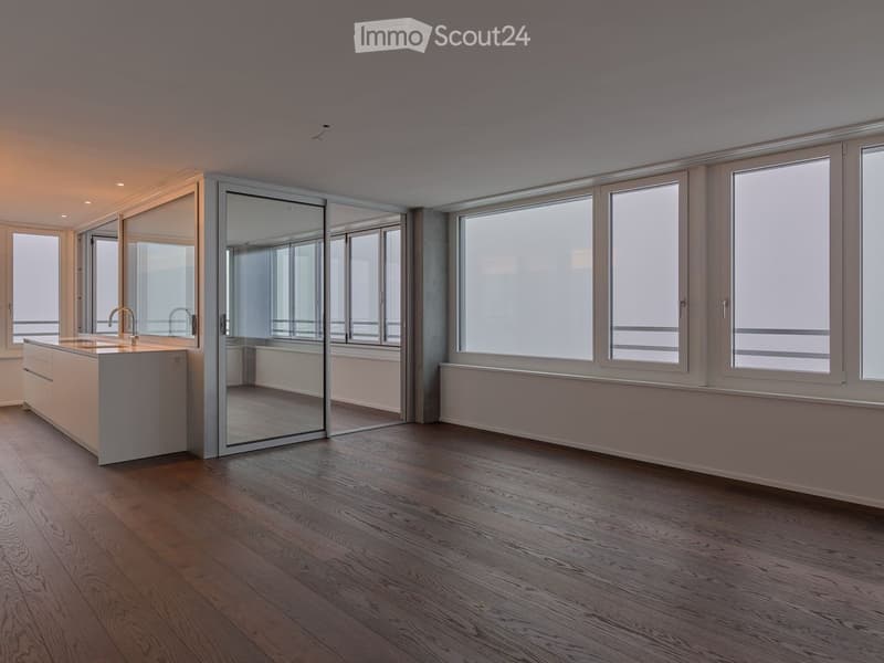 spacious room with wooden floor, glass doors, large windows, and balcony