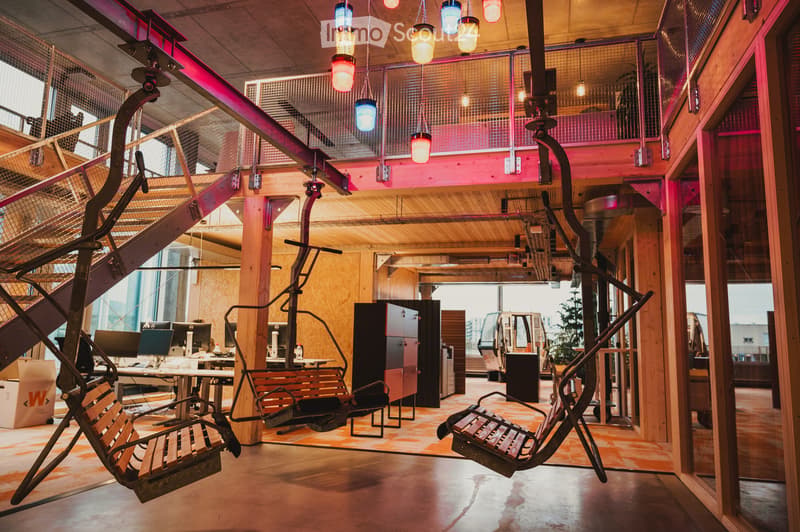 office with metal swing chairs, two large pillars, large window