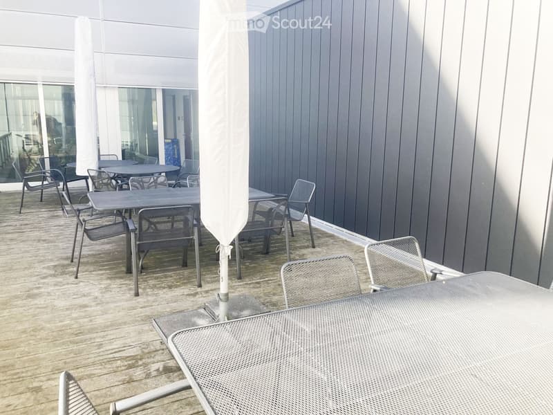 Outdoor dining area, wooden deck, metal tables and chairs, large open space