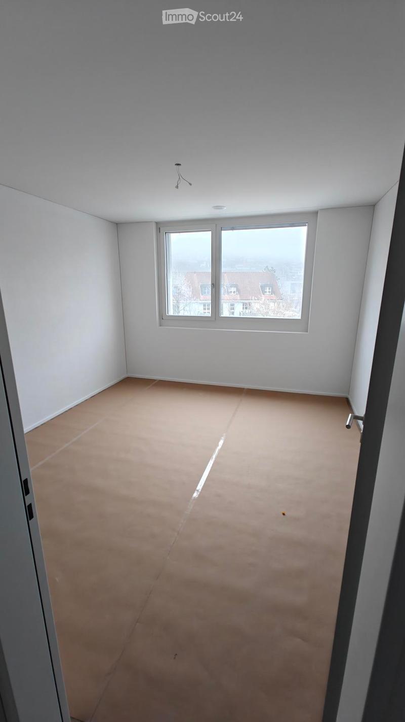 empty room, white walls, brown floor, large window, view of a house