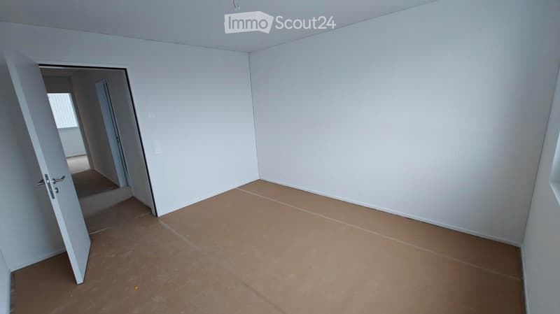 Empty room, white walls, brown floor, open door, small window
