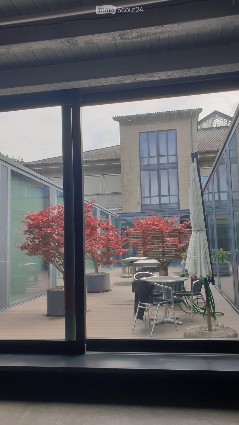 a garden view with tables and chairs, a patio with trees, and a building