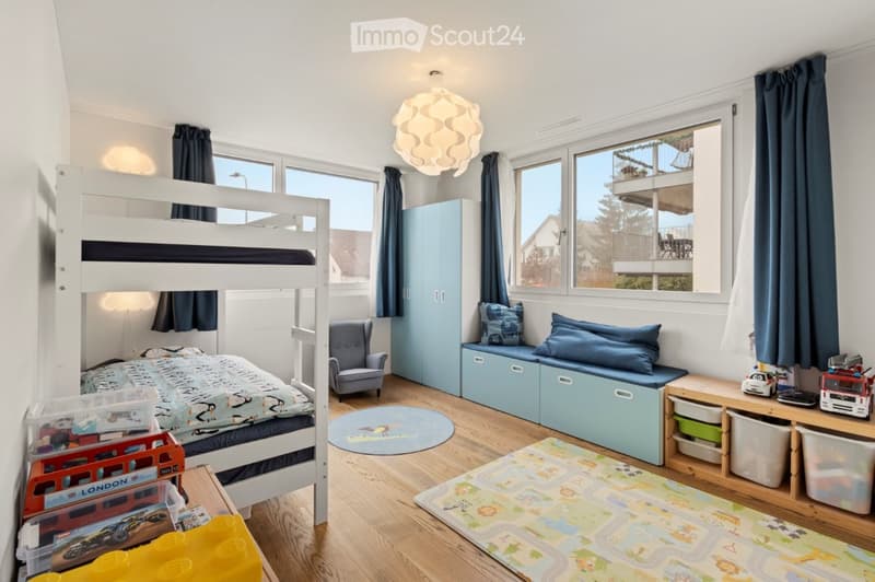 children's bedroom with bunk bed, blue cushions, toy car, floor lamp, rug, blue storage boxes