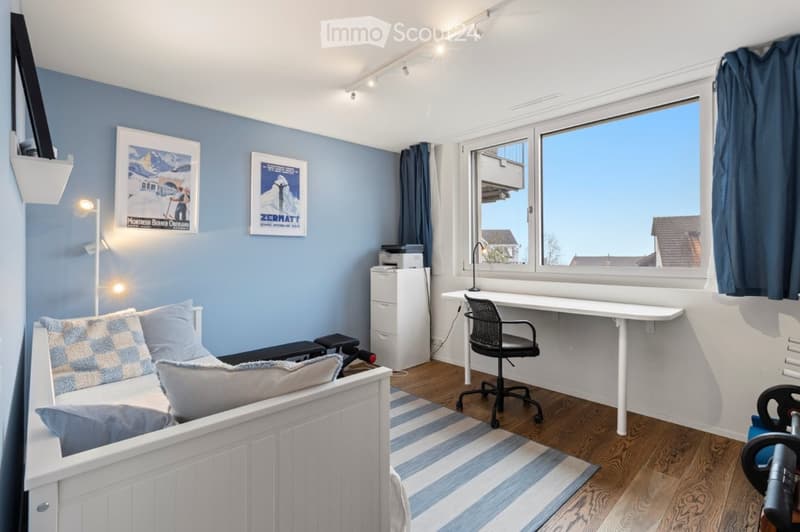 white bedroom with blue walls, bed, desk, chair, window with blue curtains