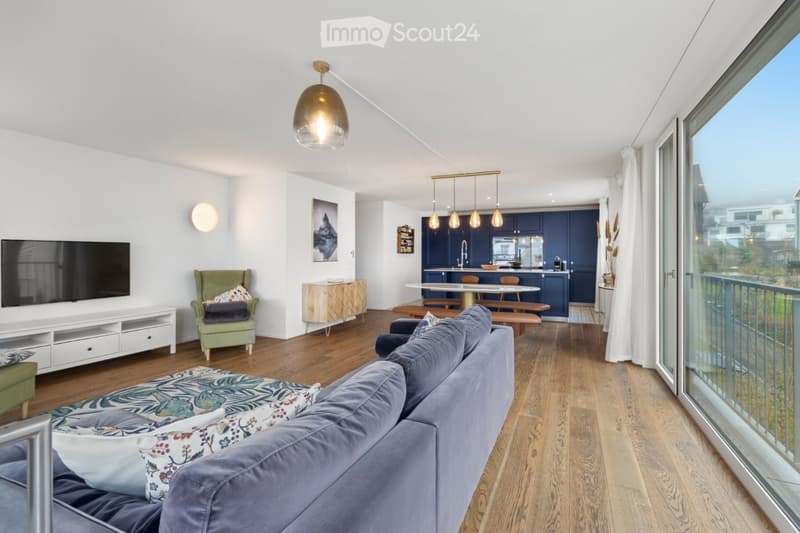 living room, couch, table, kitchen, balcony with railings, sliding glass door, television, hardwood floor, ceiling light, wall lamp, white walls, white curtains