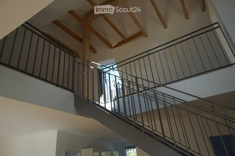 steel staircase railing, wooden ceiling beams, open staircase landing with a skylight