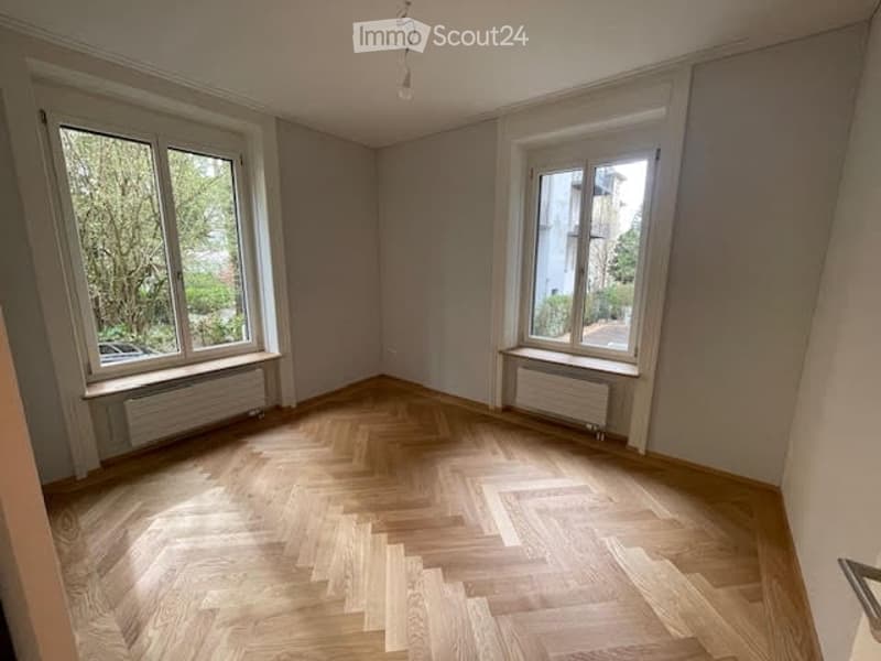 empty room, wooden floor, white walls, two large windows, radiators