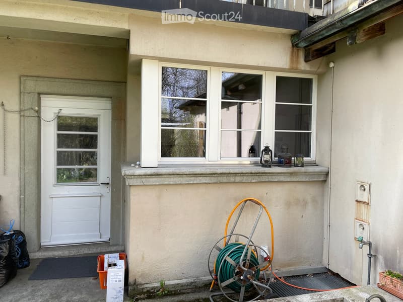 Front entrance with white door, white windows, balcony, water pipe, lamp on window sill