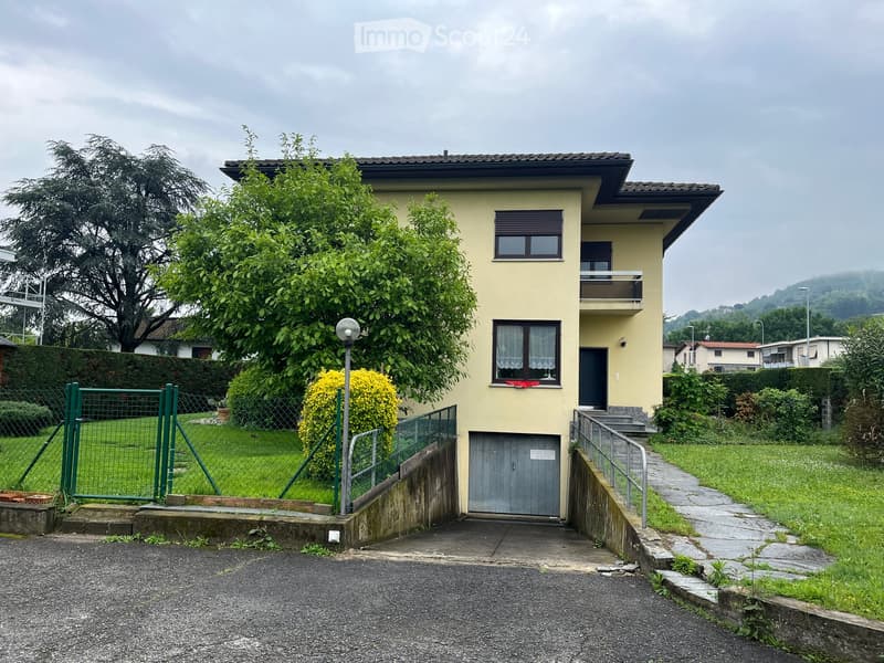 2 story house, yellow paint, garage, fenced yard, green lawn, stairs, fence, trees, lamp