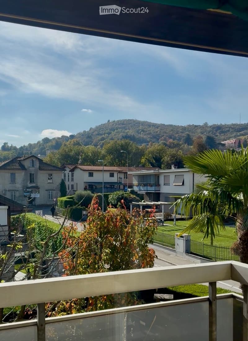 Balcony, trees, houses, fence, and mountain view