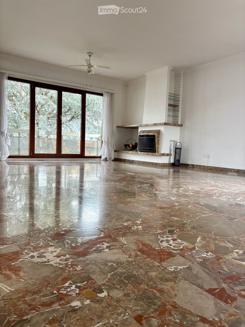 Open room with marble floor, sliding doors, balcony, fireplace, white ceiling, ceiling fan, windows with curtains