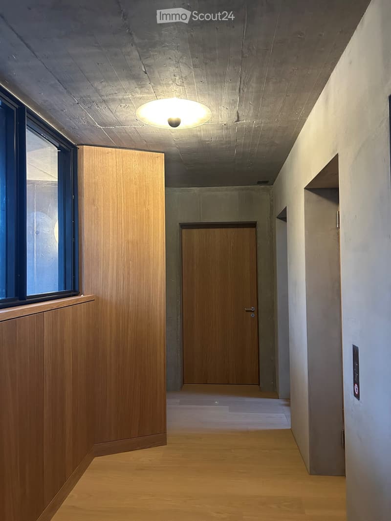 wooden paneled walls, wooden door, glass windows, grey ceiling, white walls, wooden floor