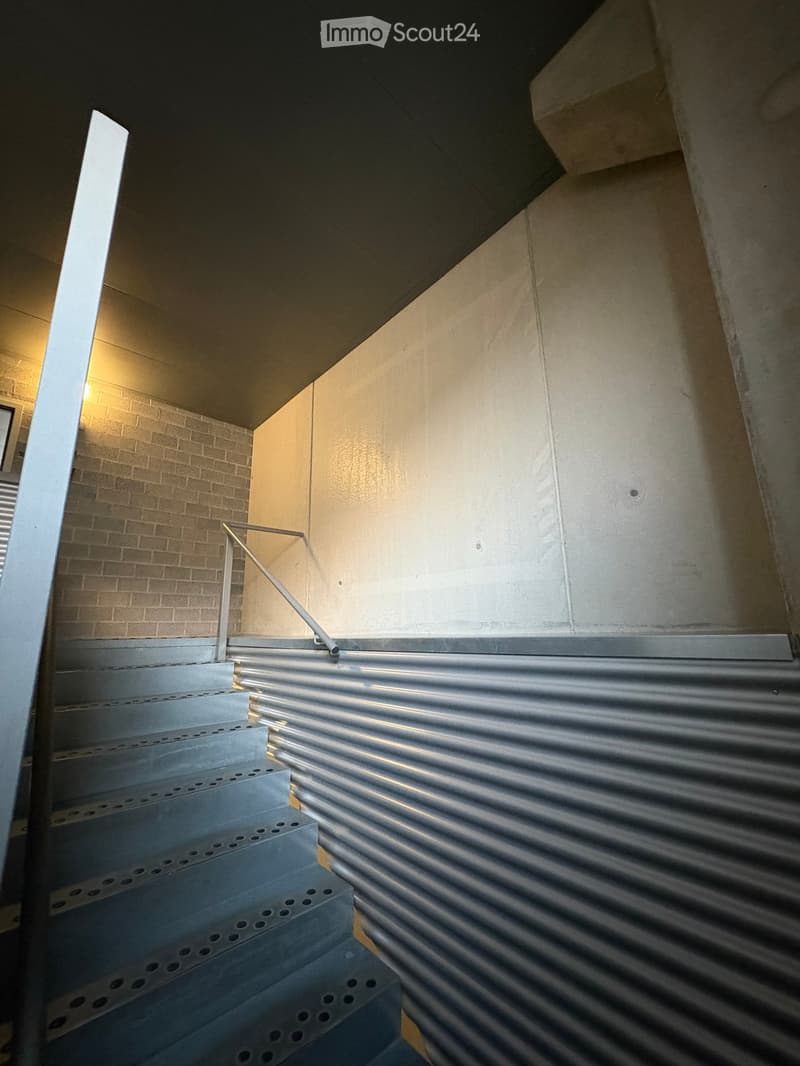 concrete staircase with metal handrail, brick wall, metal corrugated wall