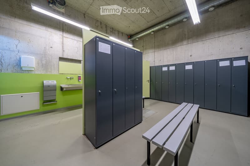 Storage room with lockers, benches, and a sink.