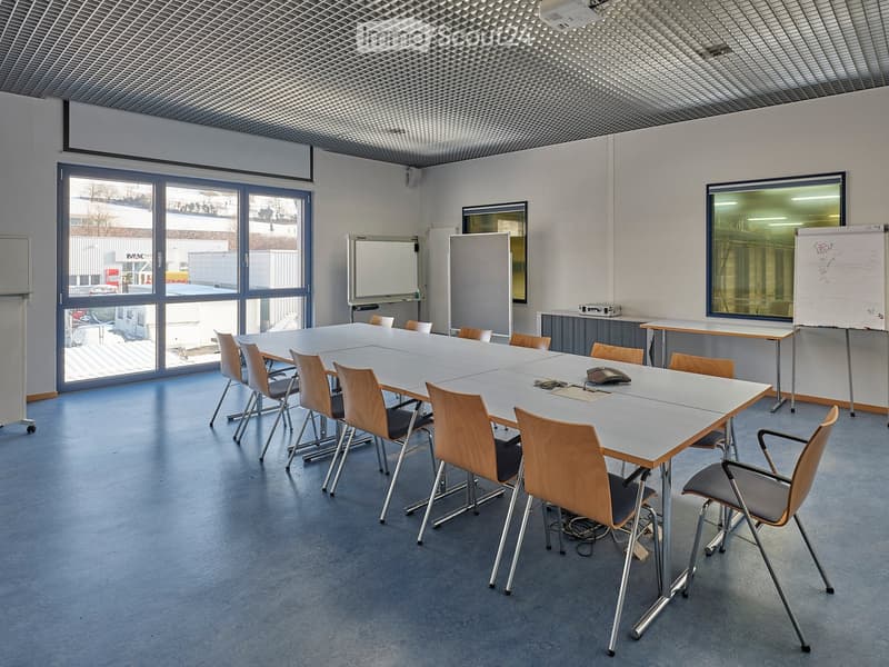 empty room with long table, chairs, whiteboards, windows, projector