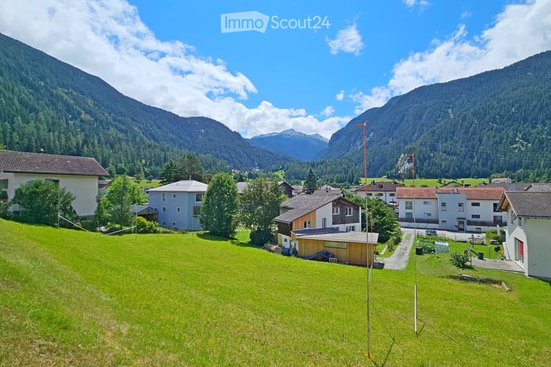Houses in a valley with mountains in the background