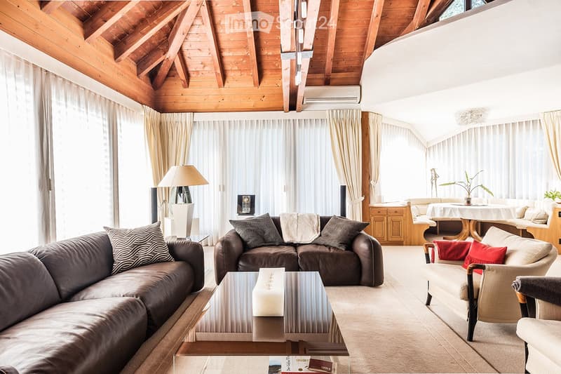 living room with wooden ceiling, large windows, brown leather couches, coffee table, lamps, carpet
