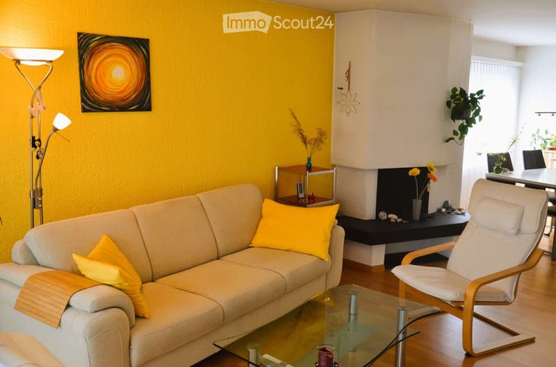 yellow wall, beige sofa, glass table, yellow pillows, floor lamp, fireplace