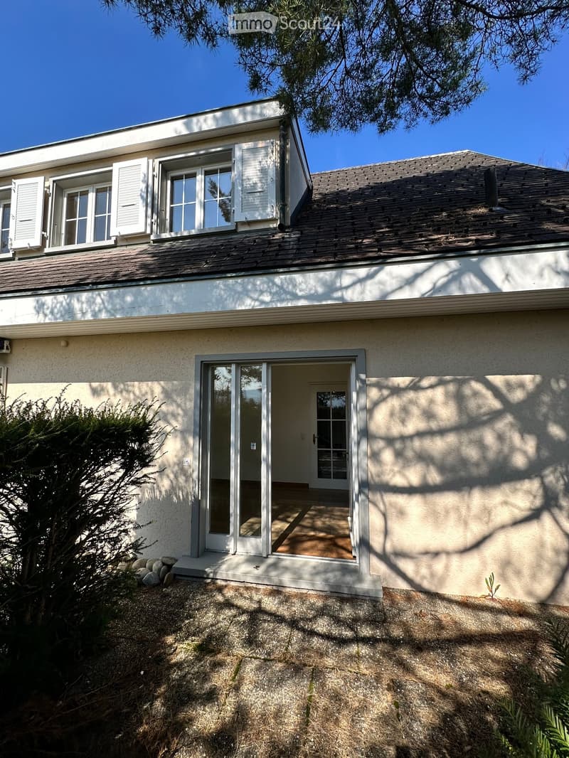 white exterior, brown roof, white shutters, glass sliding door, small porch, gravel pathway