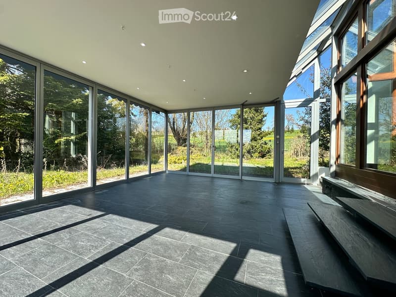 large glass windows, tiled floor, open to outdoor garden