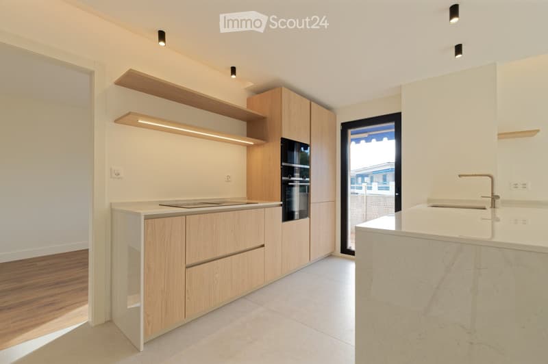 modern kitchen with wooden cabinets, white countertops, built-in oven and stove, sink with faucet, glass door leading to a balcony