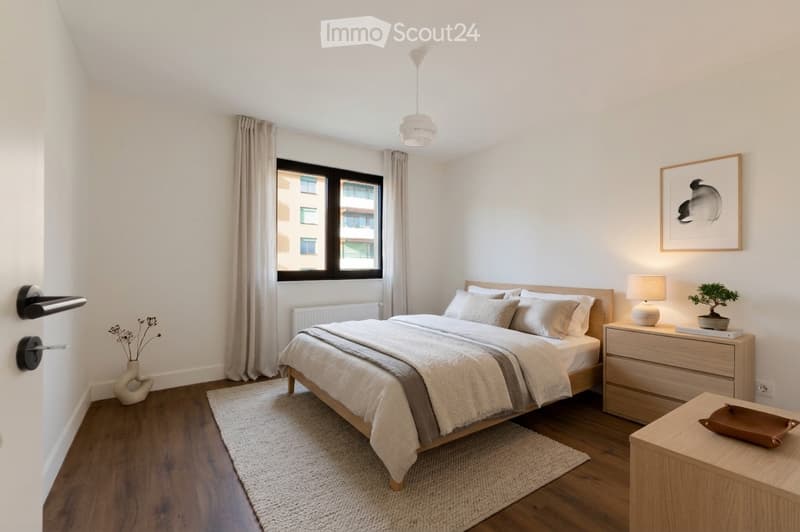 Bedroom with a bed, nightstand, lamp, and a window with a view of a building.