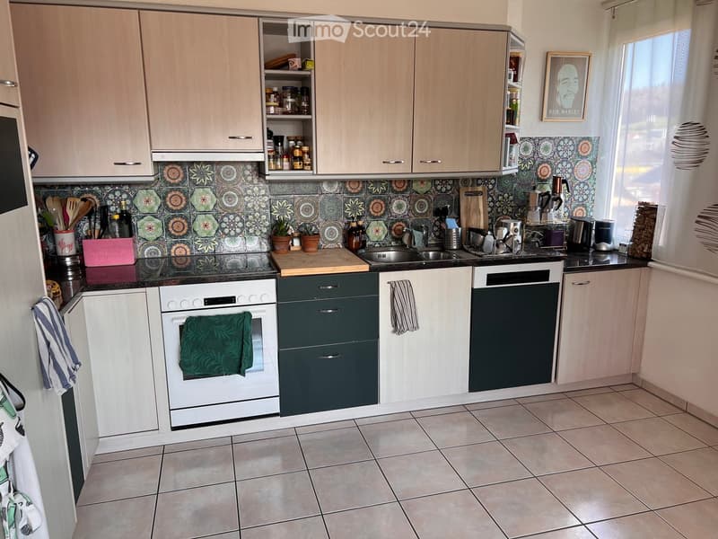 modern kitchen with wooden cabinets, black countertops, white appliances, tiled floor, decorative tiles on the wall, various kitchen utensils and appliances