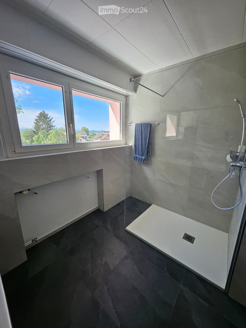 modern shower, blue towel, glass window, shiny tiles, natural light
