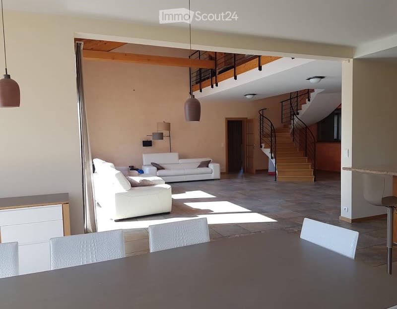 open plan living room and dining area, white leather sofas, dining table, wooden floor, staircase, lamps