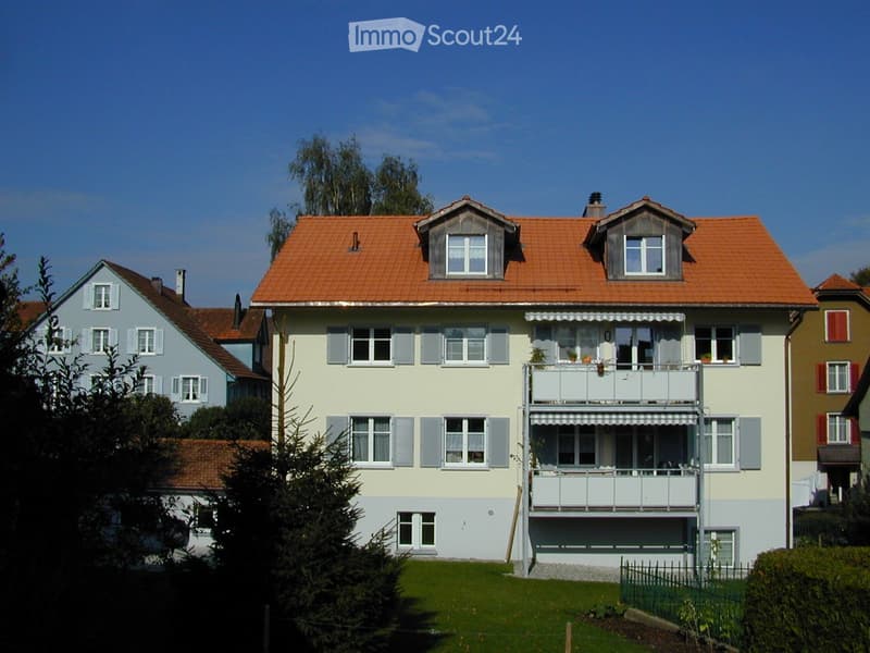 3 story house, yellow and white, red roof, multiple windows, balcony