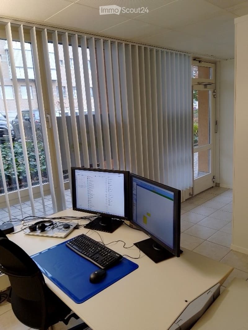Office room with desk, two monitors, keyboard, mouse, headphones, and a chair.