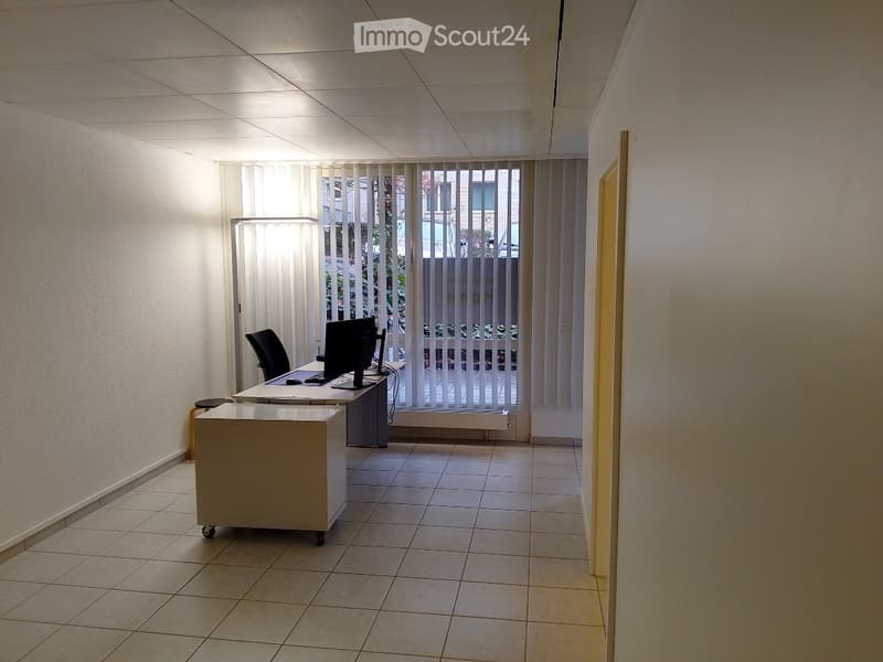 Office room with desk, computer, chair, and lamp
