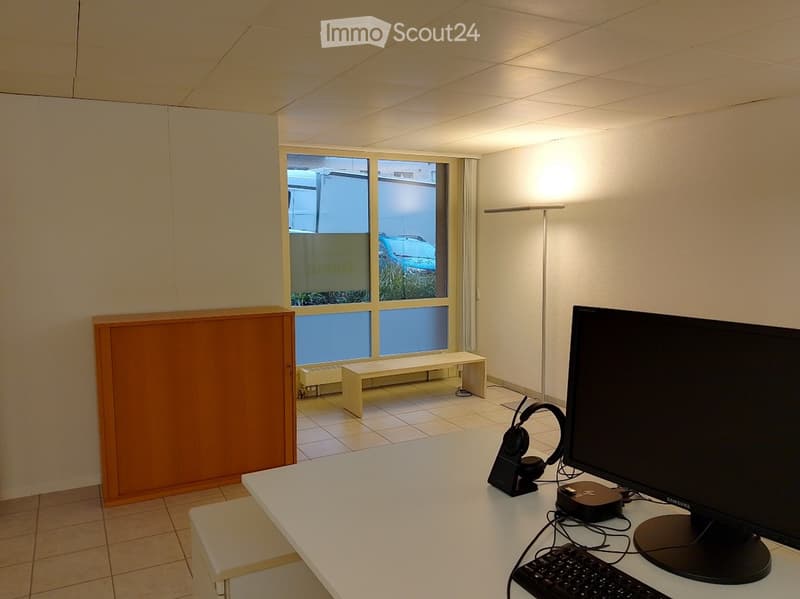 empty room, white walls, white desk, computer monitor, keyboard, headphones, bench, window, radiator